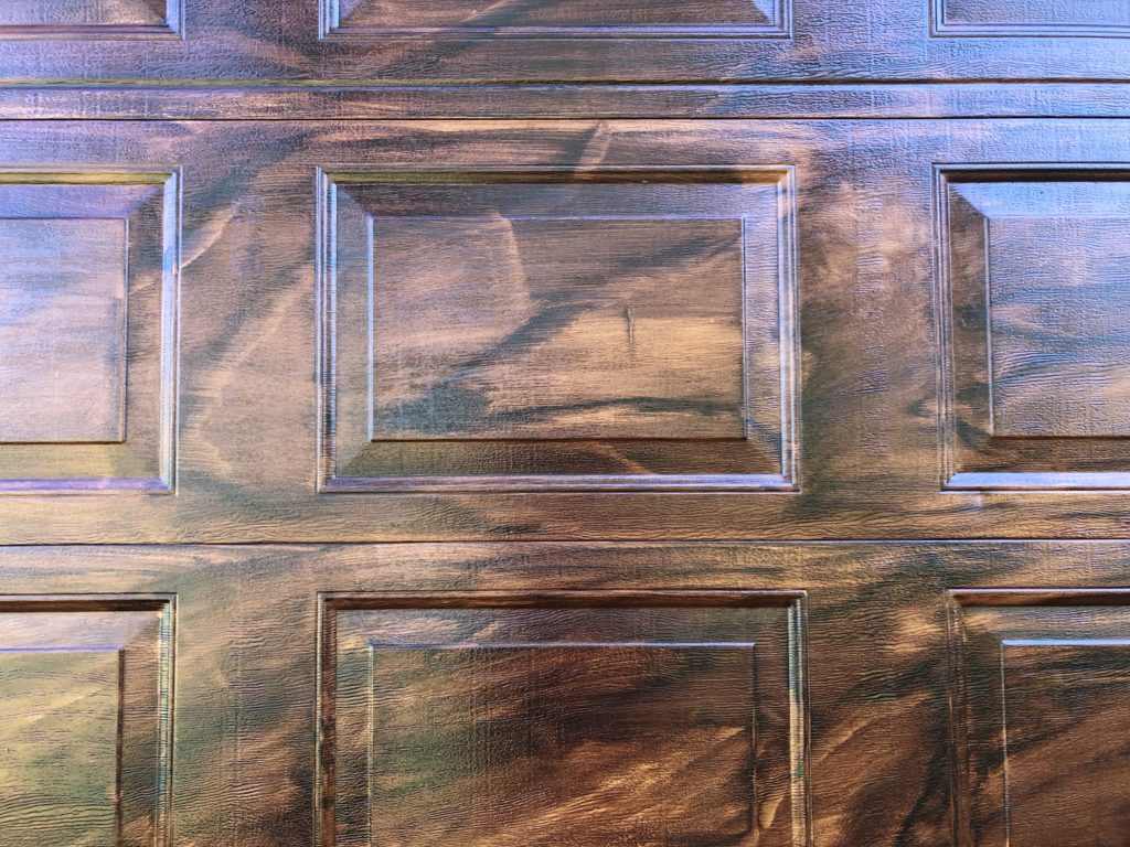 Faux wood grain shown up close on metal garage door