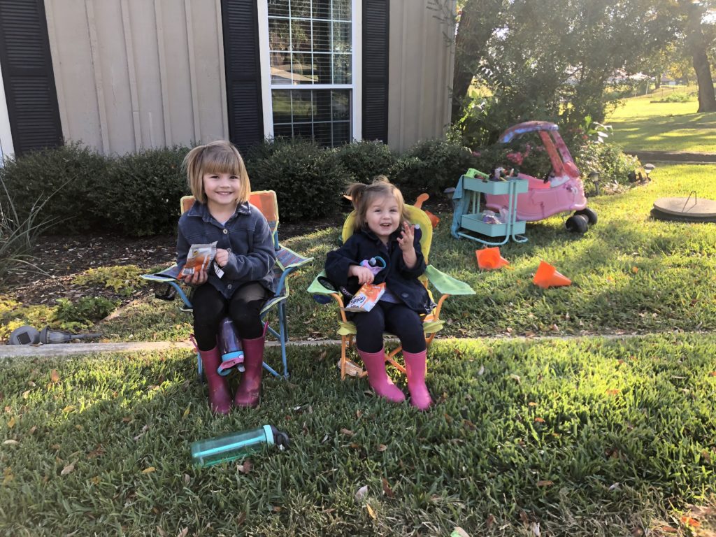 My little girls sitting in chairs watching me do the faux Wood Garage Door painting